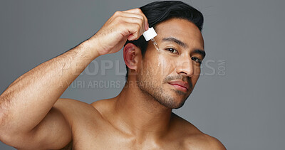 Face, pipette and Asian man with skincare, oil and dermatology on a grey studio background. Portrait, Japanese person and model with wellness, treatment and grooming product with aesthetic and glow