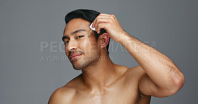 Man, face and essential oil for beauty, skincare and cosmetics product on a gray, studio background. Young asian person in portrait with facial serum, dermatology dropper or collagen for skin care
