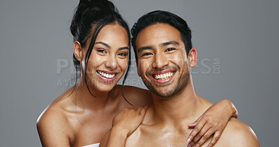 Couple, smile and care for skincare, happy and portrait for wellness in studio by gray background. Happy people, dermatology and hug for cosmetics, hydration and glow or love for skin treatment