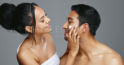 Couple, smile and love for skincare, happy and portrait with moisturizer in studio by gray background. Happy people, dermatology and hug for cosmetics, hydration and creme or care for skin treatment