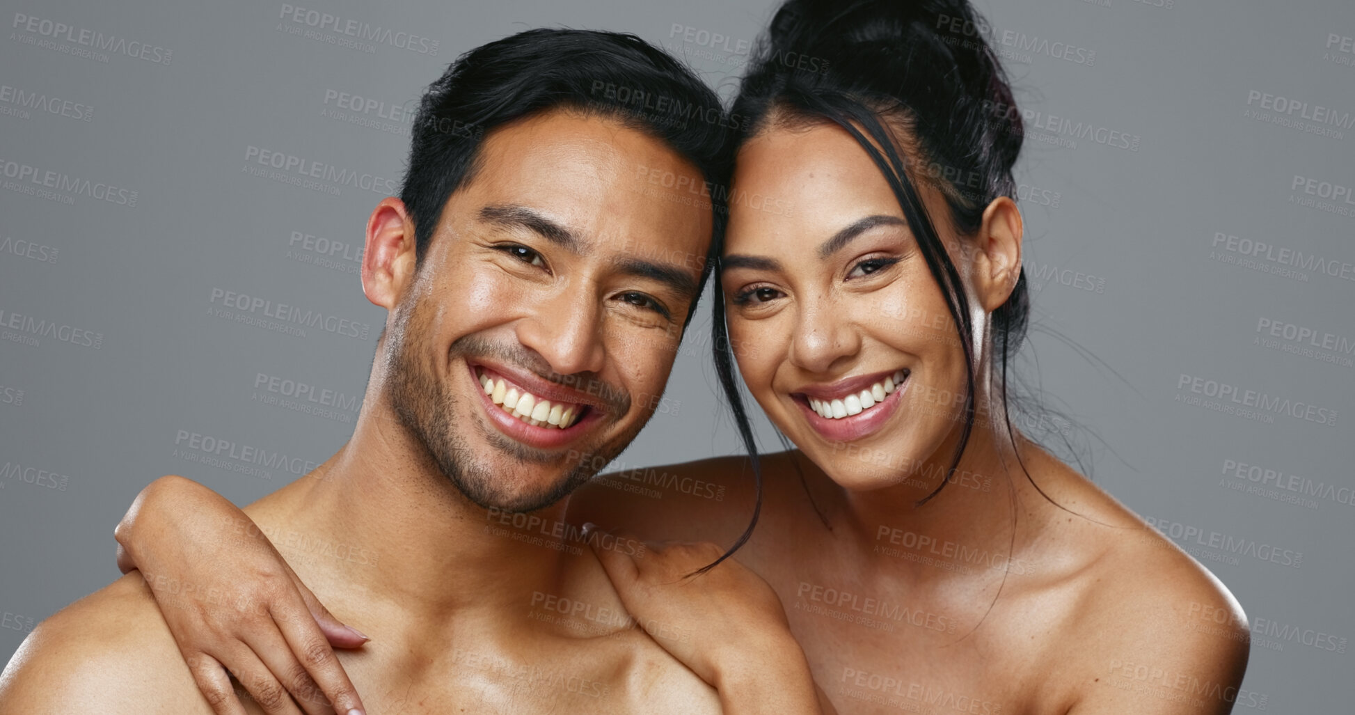 Buy stock photo Couple, smile and care for skincare, love and portrait with moisturizer in studio by gray background. Happy people, dermatology and hug for cosmetics, hydration and creme or happy for skin treatment