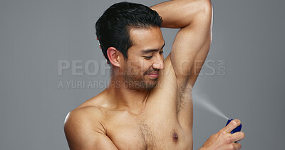 Grooming, hygiene and man spraying armpit with perfume in studio, wellness and fragrance isolated on grey background. Deodorant, beauty and cosmetic product with body care, clean and fresh with skin