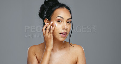 Face, skincare and happy woman with cream in studio isolated on a gray background. Portrait, natural beauty and model apply moisturizer, cosmetics and product for wellness, dermatology and health