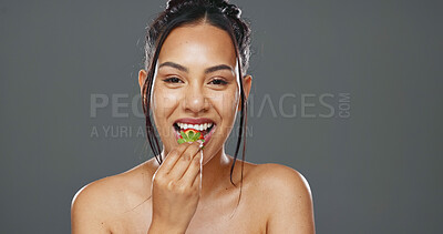 Woman, strawberry and beauty in studio for health, diet and smile on face with skincare by background. Girl, model and happy for fruit, nutrition choice and vegan food for wellness, glow or self care