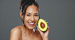 Woman, avocado and beauty in studio for health, diet or smile on face for skincare by background. Girl, model or happy for fruit, nutrition choice or vegan food for wellness, natural glow or portrait