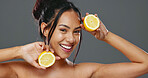 Face, skincare and woman with lemons for beauty in studio isolated on gray background. Portrait, natural fruits and food of happy model for cosmetics, healthy diet and nutrition for organic vitamin c