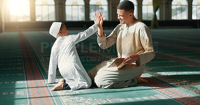 Muslim, high five in a mosque and a father with his son to study the quran for faith, belief or religion together. Family, kids and ramadan with a man teaching his boy child about islamic success