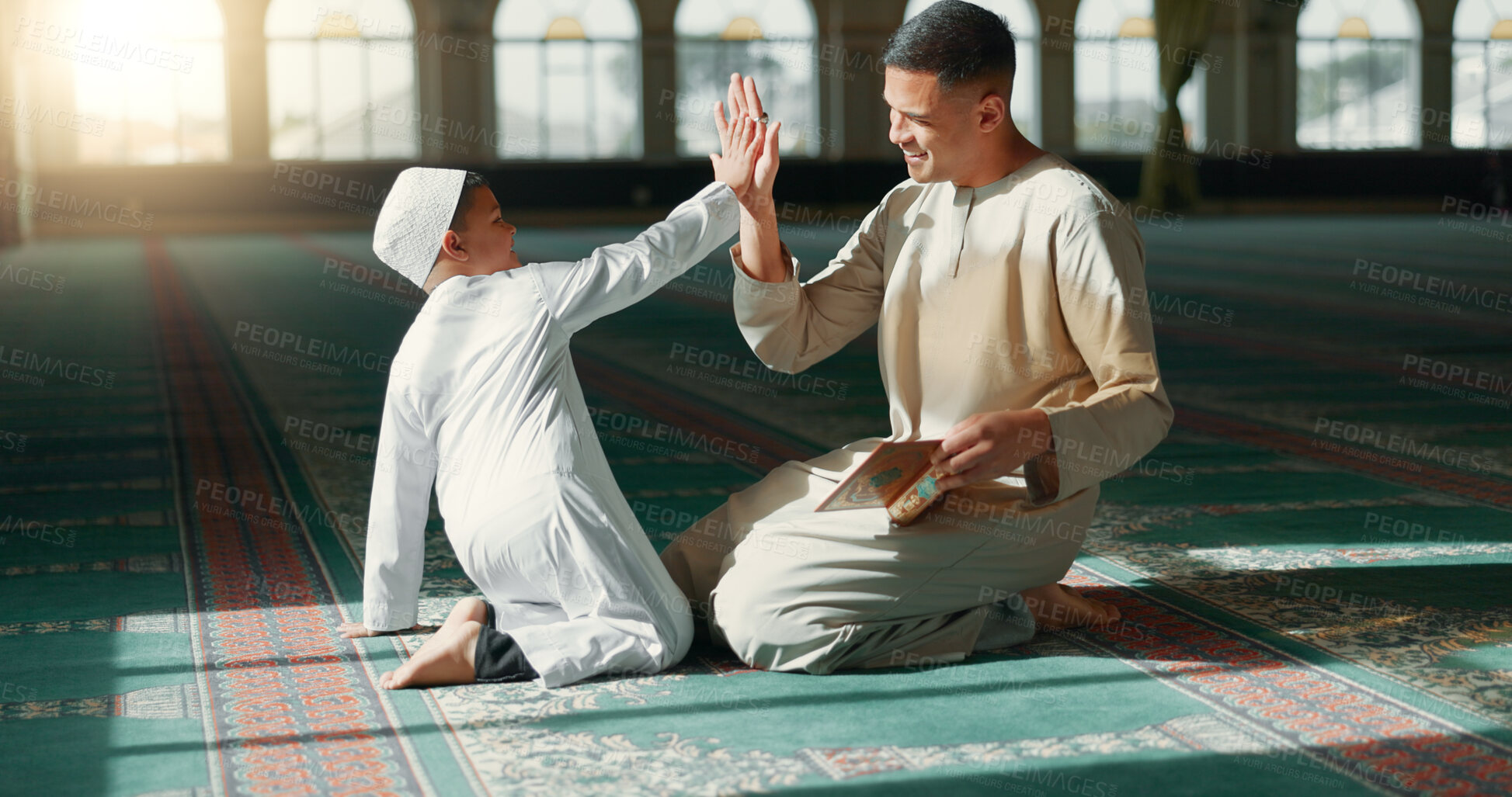 Buy stock photo Muslim, high five in a mosque and a father with his son to study the quran for faith, belief or religion together. Family, kids and ramadan with a man teaching his boy child about islamic success