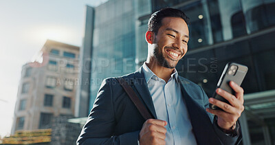 Phone, social media and wind with businessman in city, walking on street or sidewalk for morning work commute. Smile, mobile or contact with happy young employee in urban town for travel journey