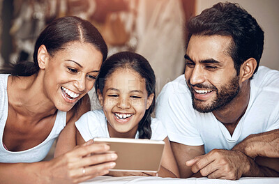 Buy stock photo Shot of a happy family using a cellphone together at home
