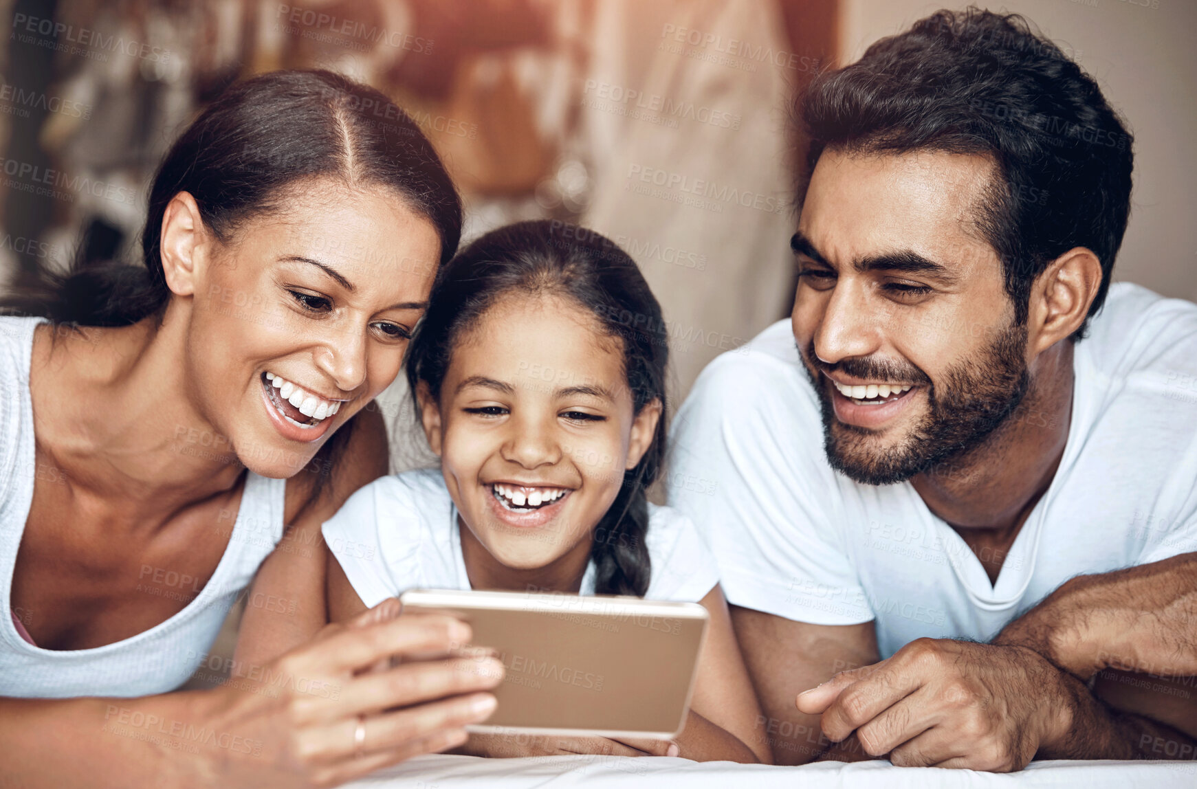 Buy stock photo Shot of a happy family using a cellphone together at home