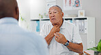 Senior, man and consulting doctor on chest pain, sore or discomfort in healthcare hospital. Mature, male person or patient talking to medical employee for heart ache, breathing or illness at clinic