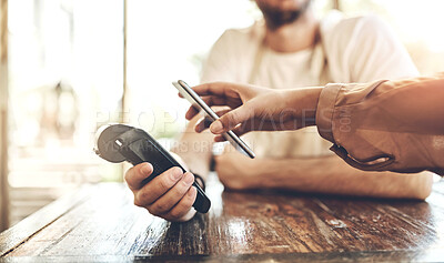 Buy stock photo Cropped shot of a customer making a wireless payment in a coffee shop