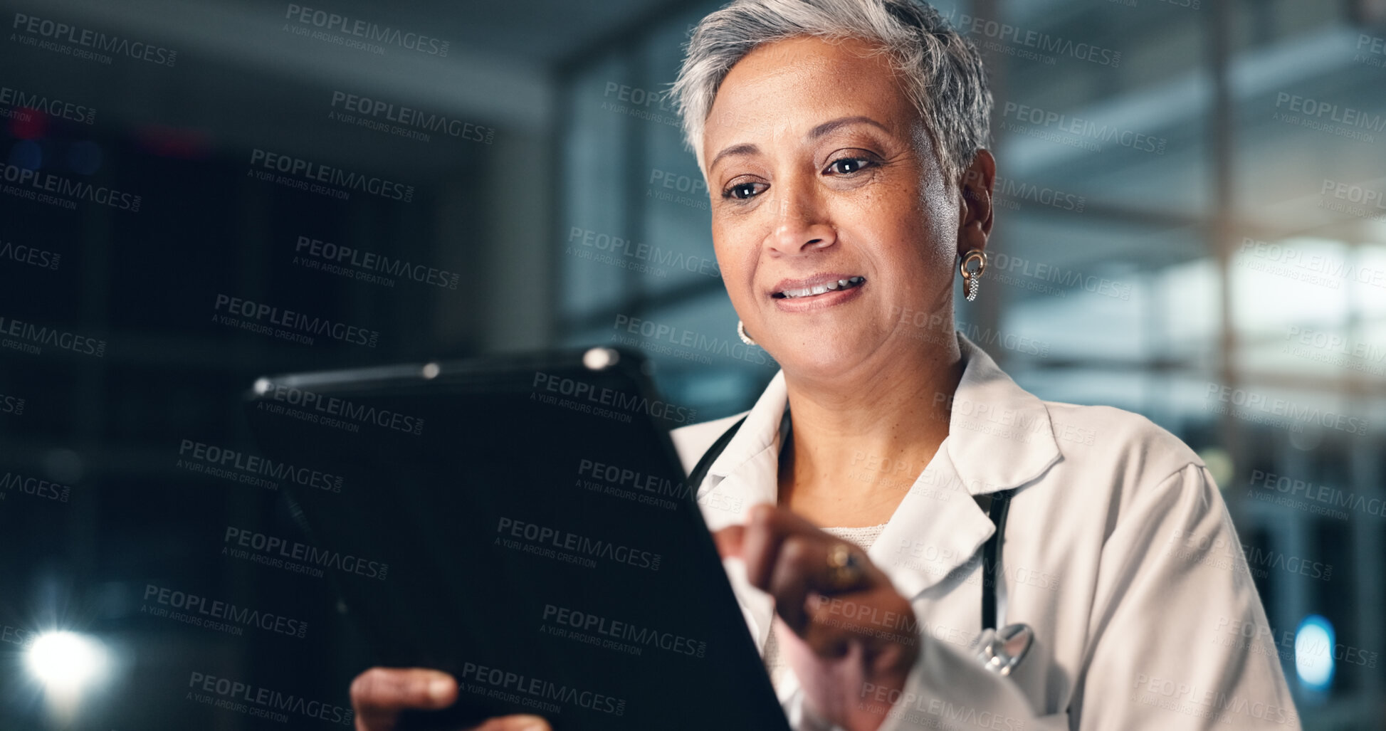 Buy stock photo Doctor, mature woman and happy with tablet in night, typing or smile for results, meme or notification in hospital. Senior nurse, digital touchscreen or funny video with click, scroll or social media