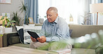 Tablet, home and senior man on sofa, reading email or ebook in living room to relax. Retirement, technology and elderly person in lounge for crossword puzzle, news and information on internet app