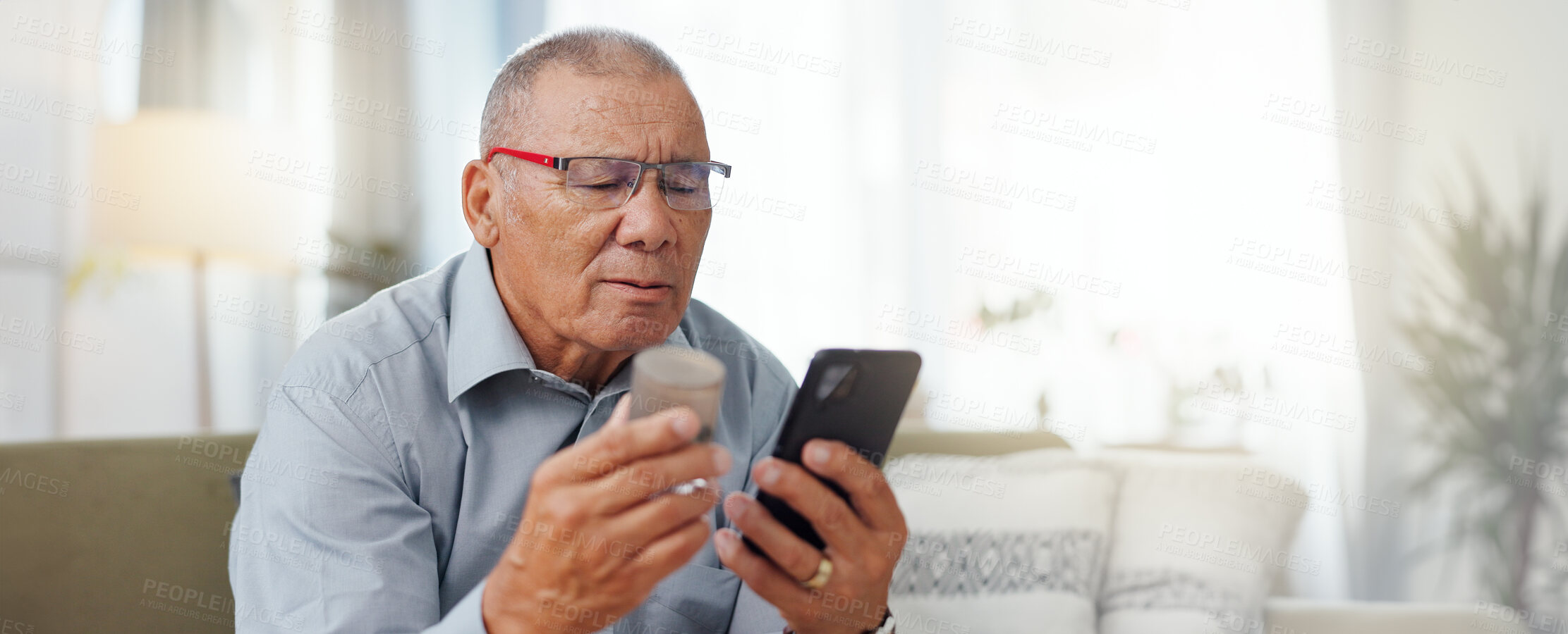 Buy stock photo Phone, medicine and senior man with home research, reading label and learning of telehealth services. Online patient with pills bottle, tablet and mobile for information or health benefits on a sofa