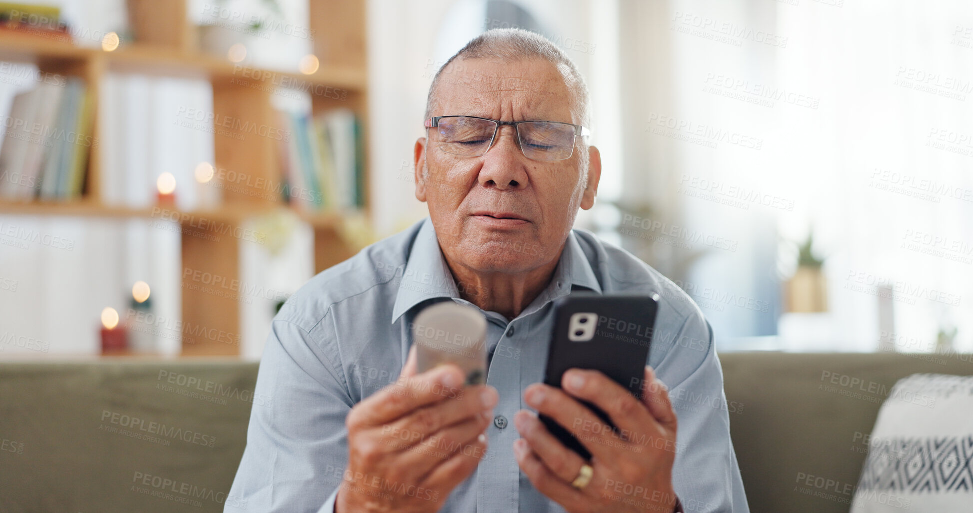 Buy stock photo Phone, pills and senior man at home, reading label, medicine information and confused for telehealth service or FAQ. Elderly person on sofa with pharmaceutical bottle or tablet with mobile questions