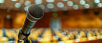 Microphone, public speaking and conference setup in an empty hall for event planning, convention and workshop. Closeup, banner and equipment for corporate business, marketing strategy or announcement