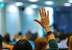 Raised hand, people and audience asking or voting at business meeting, conference or trading seminar. Hall, closeup and back view for convention, workshop gathering, or ask a question in workplace