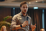 Businessman, conference or speaker holding a microphone at a business seminar for knowledge, motivational or coaching. Confident, man or coach speaks to audience at a convention or corporate event