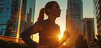 Woman, running and athlete on a morning run in the city for training, fitness and workout. Confident, determined and focused female jogging at sunrise for marathon training, competition or exercise