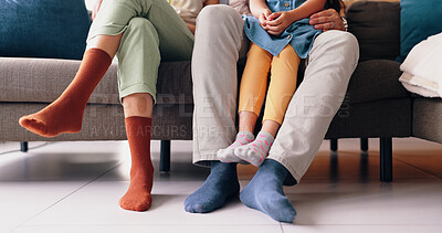 Feet of mom, dad and kid on sofa with socks, love and bonding together in living room of home. Legs of family with father, mother and daughter sitting on couch, relax and care in lounge of apartment.