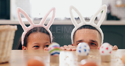 Child, father and easter with eggs, happy or thinking at table for game, festive holiday or celebration. Dad, kid and bunny ears for rabbit costume, ideas or playful for love, bonding and family home