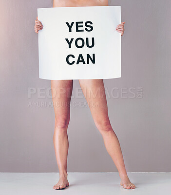 Buy stock photo Studio portrait of an attractive young woman holding a sign that reads “yes you can” against a pink background