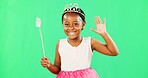 Children, wave and wand with a girl on a green screen background in studio playing fantasy or dress up. Portrait, kids and magic with an adorable little female child waving on chromakey background