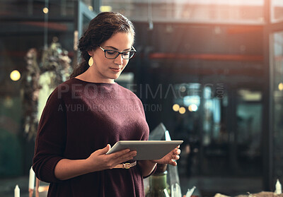 Buy stock photo Cropped shot of an attractive young female entrepreneur using a tablet in her store