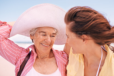 Buy stock photo Smile, wind and senior mother on beach with daughter in summer for travel, holiday or vacation. Face, love or bonding with woman and happy elderly parent outdoor together for weekend getaway