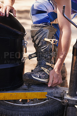 Buy stock photo Person, hands and boots of professional motorcyclist preparing for race, competition or extreme sports. Closeup of dirt biker or rider checking foot for grip, safety or mobility on off road track