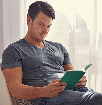 Buy stock photo Happy man, relax and reading with book on chair in living room for story, literature or novel at home. Handsome male person or young adult with smile for information, knowledge or learning in leisure