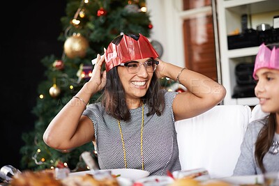 Buy stock photo Hat, Christmas and mom with daughter at table for festive bonding, smile and eating together in home. Holiday, celebration and happy mother with food, child xmas dinner tradition with family at tree