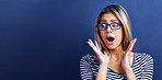 Studio, news and woman in shock with hands for promo or deal for clothes in fashion, sale and discount. Adult, female person and girl in blue background with glasses, aesthetic and announcement