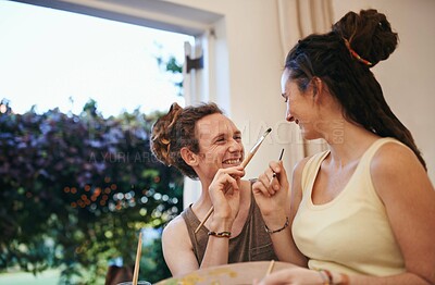 Buy stock photo A young couple painting together and having fun