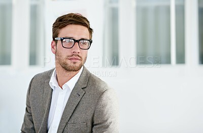 Buy stock photo Shot of a young man standing in an office. The commercial designs displayed represent a simulation of a real product and have been changed or altered enough by our team of retouching and design specialists so that they don't have copyright infringements