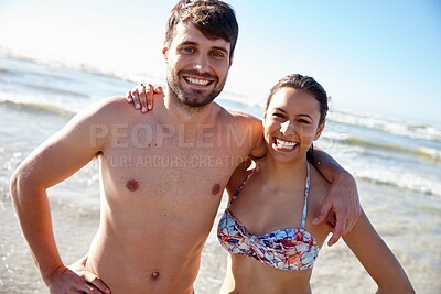 Buy stock photo Portrait shot of a happy young couple posing affectionately at the beach