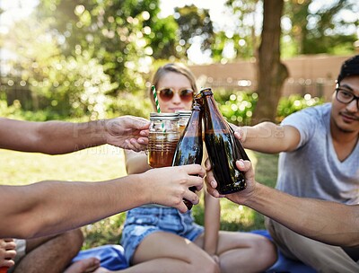 Buy stock photo Cropped shot of a young group of friends toasting while enjoying a few drinks outside in the summer sun