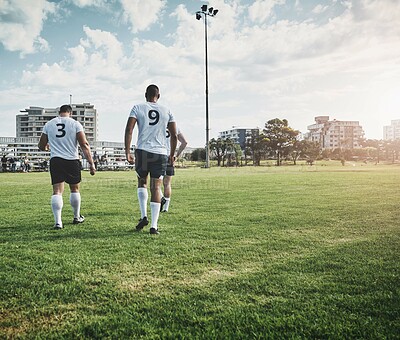 Buy stock photo Shot of a group of young rugby players walking off the filed after the match outside during the day