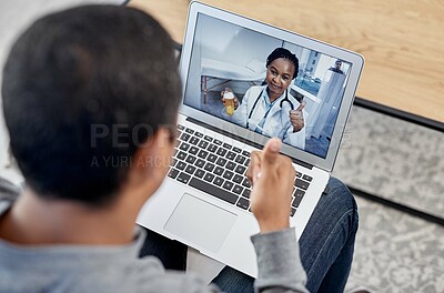 Buy stock photo Shot of a young doctor showing thumbs up while holding a bottle of pills during a consultation with a patient on a laptop