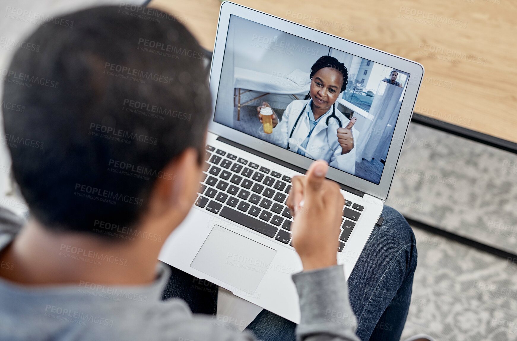 Buy stock photo Shot of a young doctor showing thumbs up while holding a bottle of pills during a consultation with a patient on a laptop