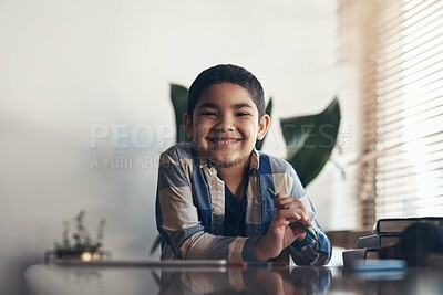 Buy stock photo Portrait of an adorable little boy completing a school assignment at home