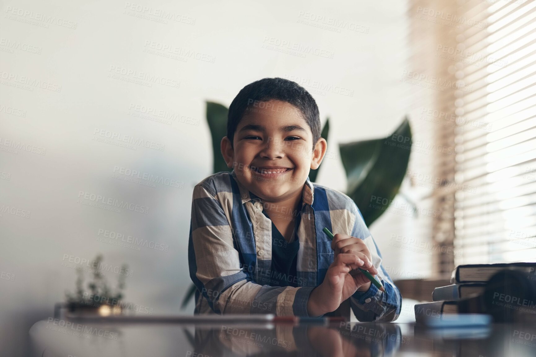 Buy stock photo Portrait of an adorable little boy completing a school assignment at home