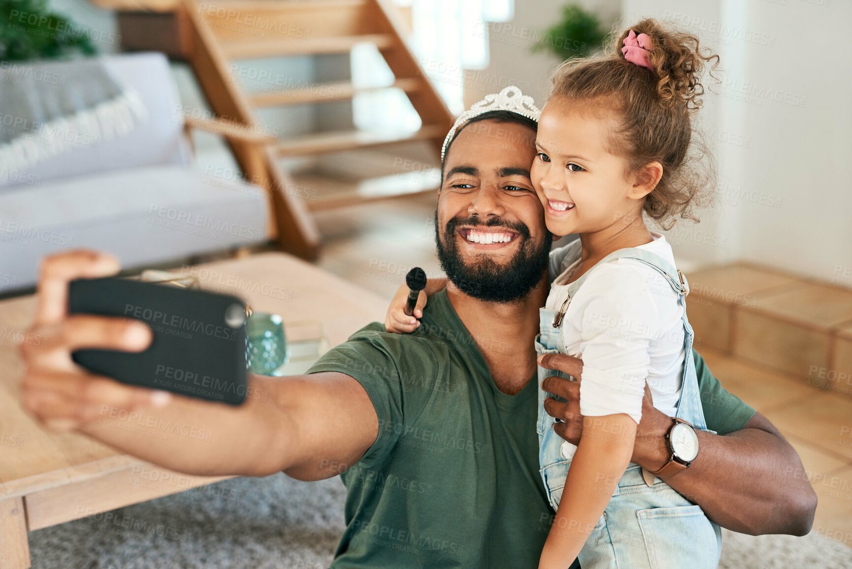 Buy stock photo Shot of a father and his little daughter taking selfies while playing together at home