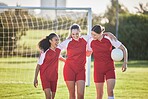 Fun female football players or friends in sportswear hugging, smiling and bonding together after practicing on a field. Young soccer enthusiasts in uniform talking about good, exciting match on field