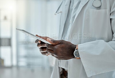 Buy stock photo Doctor holding and using a digital tablet while working at a hospital alone. Medical professional doing research on a digital tablet while at work at a clinic