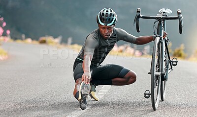 Buy stock photo Outdoor, cycling and cyclist doing stretching exercise by his bicycle on road in mountain. Sports, training for fitness and man athlete doing warm up before cardio cycle workout with bike in nature.