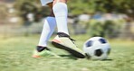 Soccer, grass and legs kick a football in a training game, practice workout and sports match on soccer field. Fitness, shoes and soccer player in action playing in cardio exercise outdoors in Brazil