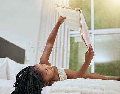 Buy stock photo Kid reading story book in bed, relax and enjoy fairytale for entertainment, child development and literature. Story time, youth life growth and learning black girl read cartoon books in bedroom 